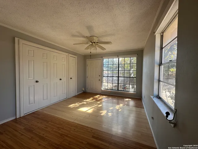 a kitchen with granite countertop a stove a sink dishwasher and white cabinets with wooden floor