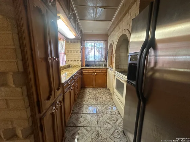 a view of an empty room with a chandelier fan