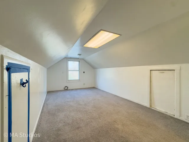 an empty room with windows and refrigerator