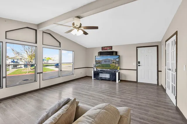 a living room with furniture and a open kitchen view