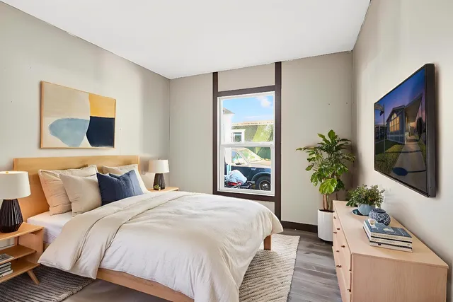 a bed sitting in a bedroom next to a window