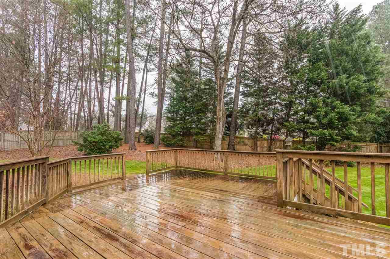 8300 Dunwood Court Raleigh, NC 27613 - Photo 17 of 18 a view of deck with large trees and wooden fence