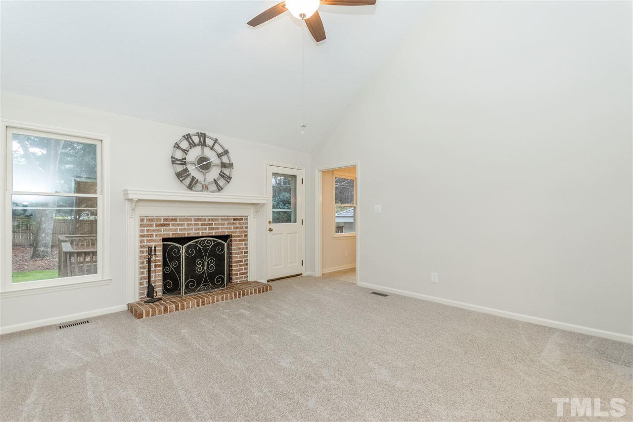 8300 Dunwood Court Raleigh, NC 27613 - Photo 5 of 18 an empty room with furniture and a fireplace