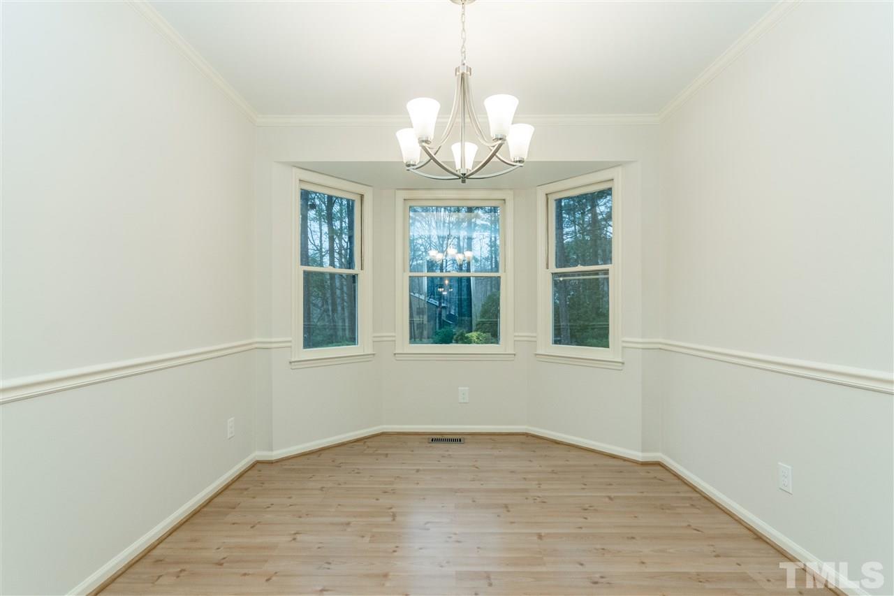 8300 Dunwood Court Raleigh, NC 27613 - Photo 7 of 18 a view of an empty room with wooden floor and a window