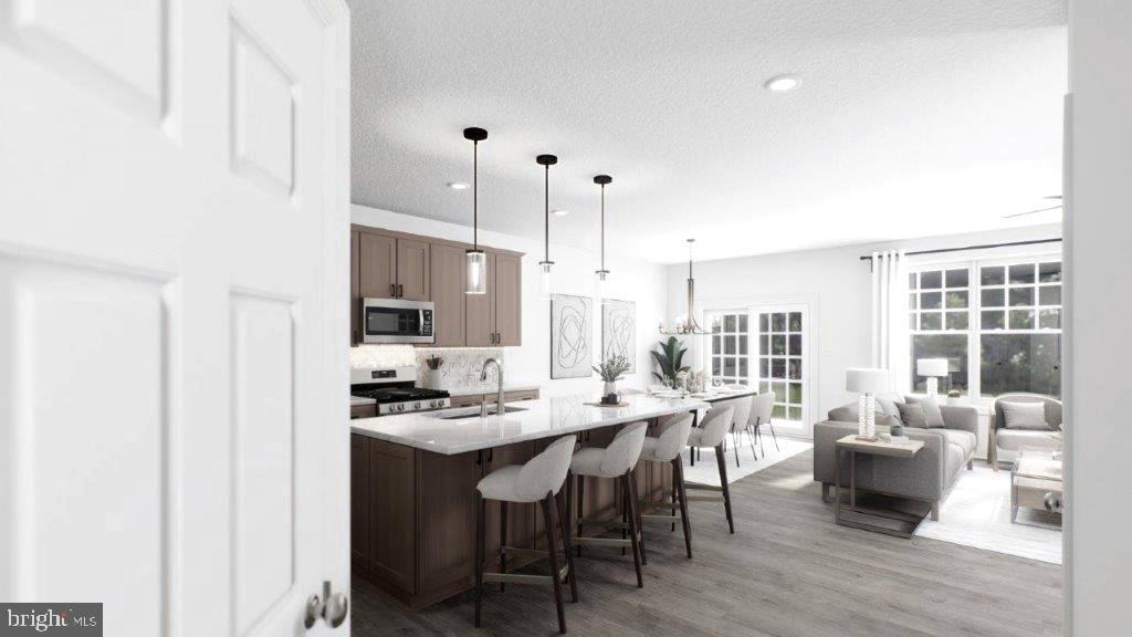 523 Linfield Road, Unit WESTERLY Royersford, PA 19468 - Photo 7 of 10 a dining hall with stainless steel appliances kitchen island granite countertop a sink table and chairs