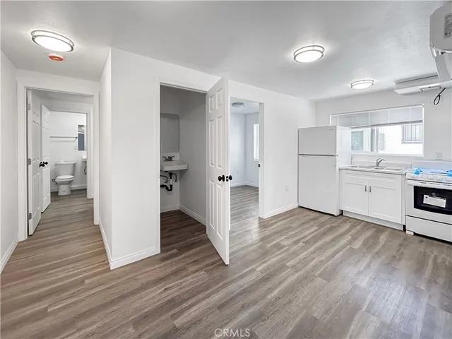 a view of a kitchen with wooden floor and a sink