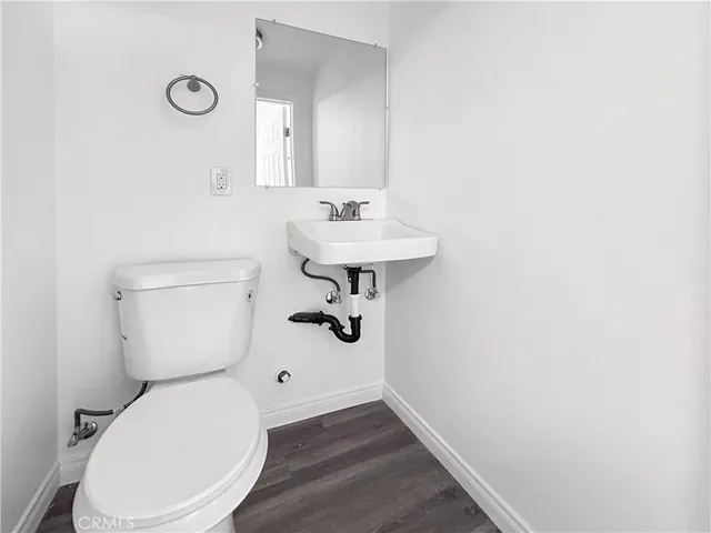 a bathroom with a toilet a sink and mirror