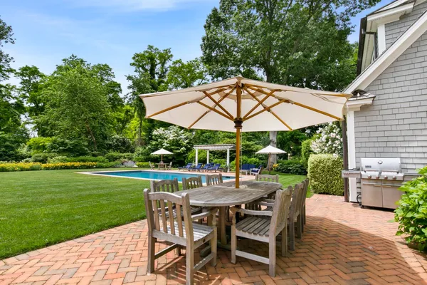 a view of patio with chairs and table under an umbrella
