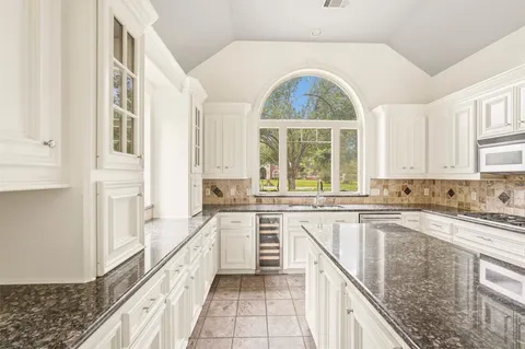 a large kitchen with granite countertop a stove a sink and a granite counter tops