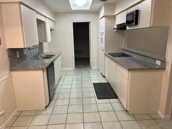 a kitchen with a sink a stove top oven and cabinets