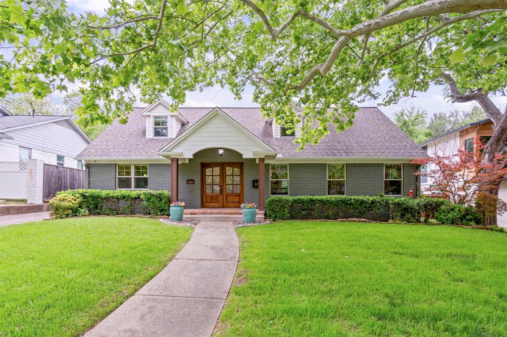 Cape cod-style house featuring brick siding, a shingled roof, and french doors