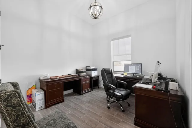 a view of a workspace with furniture and a window