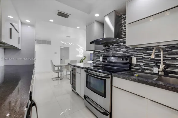 a kitchen with stainless steel appliances granite countertop a stove and a sink