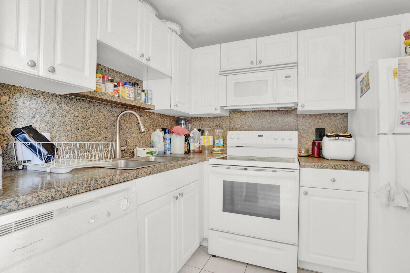 1505 Crescent Circle, Unit A11 Lake Park, FL 33403 - Photo 4 of 14 a kitchen with granite countertop white cabinets and white appliances