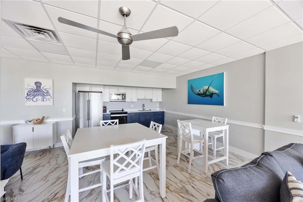 5 Bluebill Avenue, Unit 108 Naples, FL 34108 - Photo 12 of 49 Dining room with radiator heating unit, light marble finish flooring, a drop ceiling, and ceiling fan