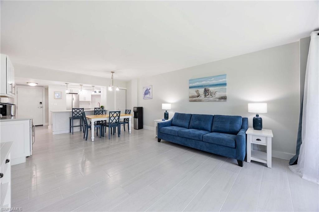 5 Bluebill Avenue, Unit 108 Naples, FL 34108 - Photo 15 of 49 Living area featuring baseboards