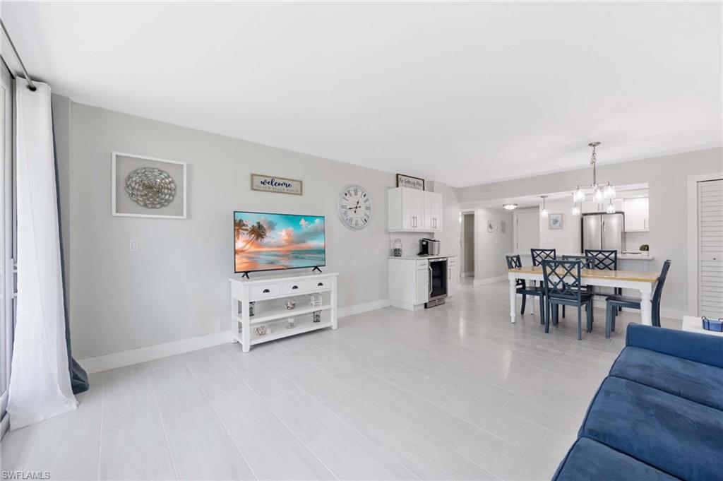 5 Bluebill Avenue, Unit 108 Naples, FL 34108 - Photo 16 of 49 Living room with wine cooler and a chandelier