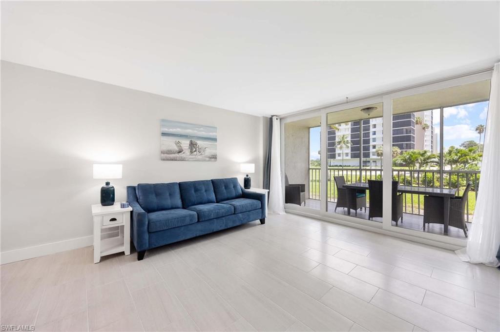 5 Bluebill Avenue, Unit 108 Naples, FL 34108 - Photo 17 of 49 Living room with floor to ceiling windows and healthy amount of natural light
