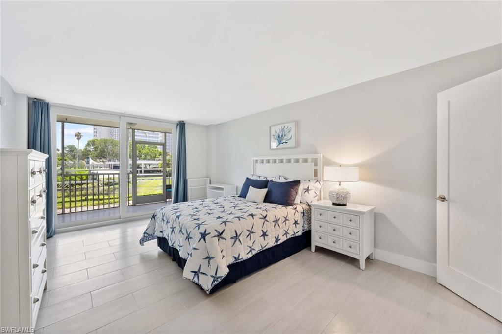 5 Bluebill Avenue, Unit 108 Naples, FL 34108 - Photo 21 of 49 Bedroom featuring access to exterior and baseboards