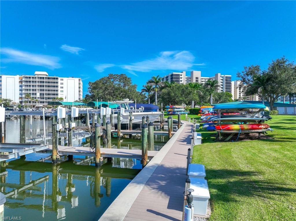 5 Bluebill Avenue, Unit 108 Naples, FL 34108 - Photo 32 of 49 Dock area with boat lift, a yard, and a water view