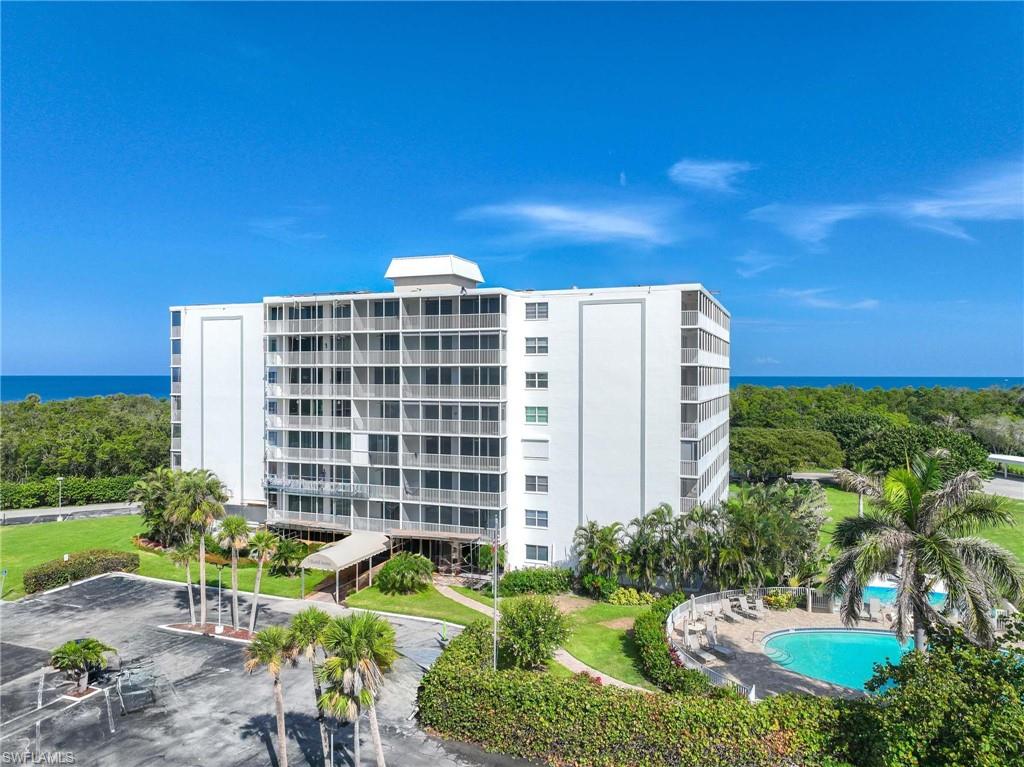 5 Bluebill Avenue, Unit 108 Naples, FL 34108 - Photo 37 of 49 View of apartment building / complex with a water view and a community pool