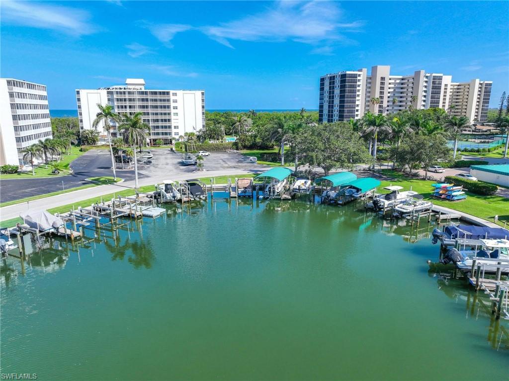 5 Bluebill Avenue, Unit 108 Naples, FL 34108 - Photo 47 of 49 Drone / aerial view of a nearby body of water and apartment complex