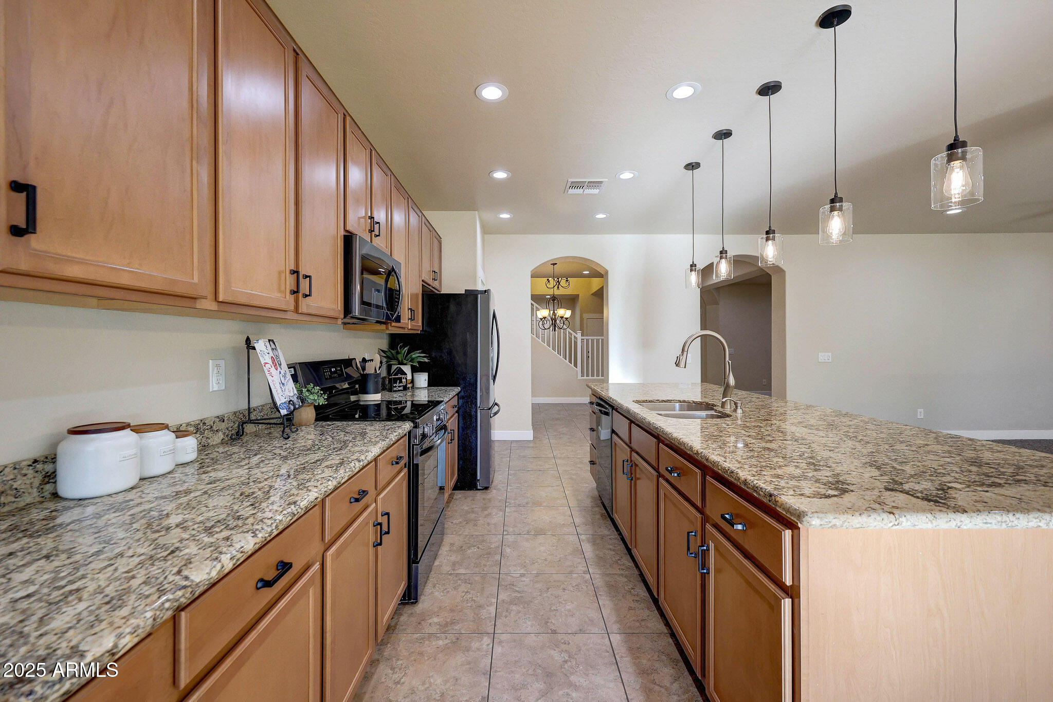 20719 West Hamilton Street Buckeye, AZ 85396 - Photo 19 of 100 a kitchen with stainless steel appliances granite countertop a sink a stove and a wooden cabinets