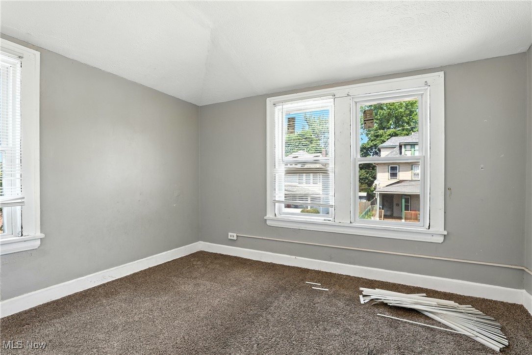 1774 Urbana Road Cleveland, OH 44112 - Photo 27 of 41 Empty room featuring dark carpet and baseboards