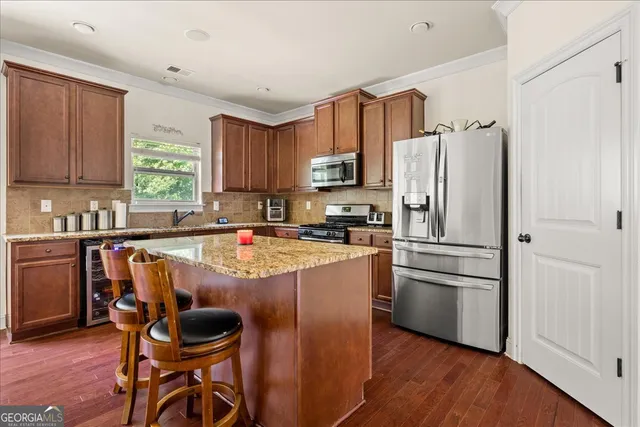 a kitchen with kitchen island a refrigerator and a stove top oven