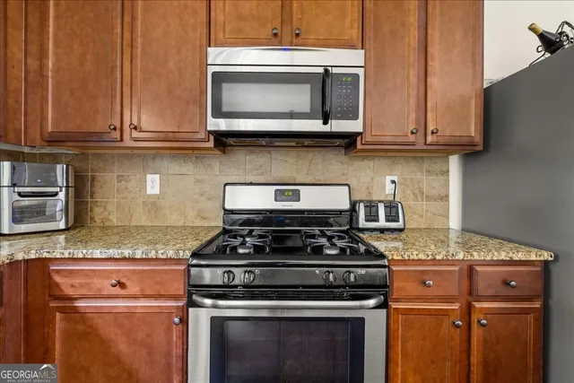 a kitchen with granite countertop stainless steel appliances and cabinets