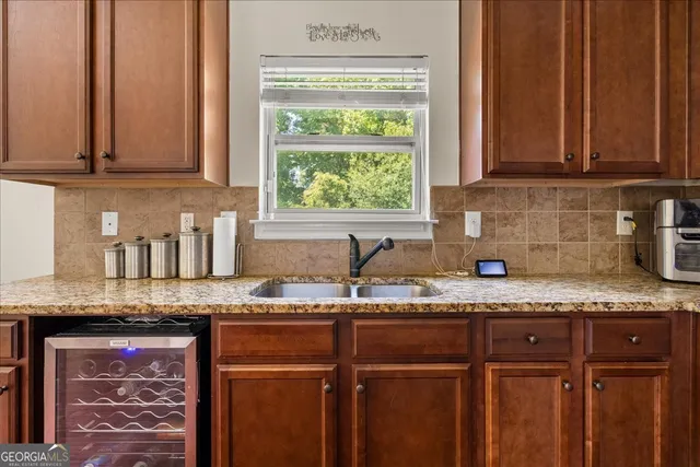 a kitchen with granite countertop stainless steel appliances a sink window and cabinets