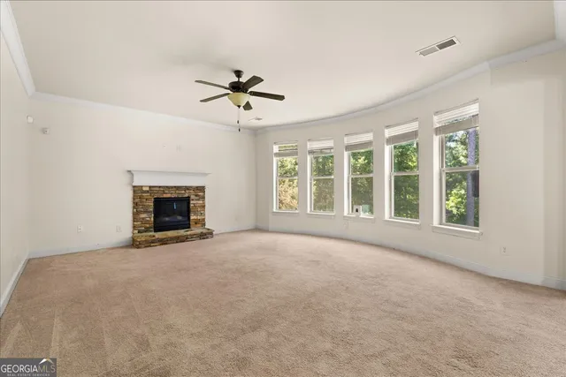 a view of an empty room with a fireplace and a window