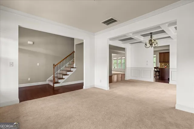 a view of an empty room with a fireplace and a chandelier