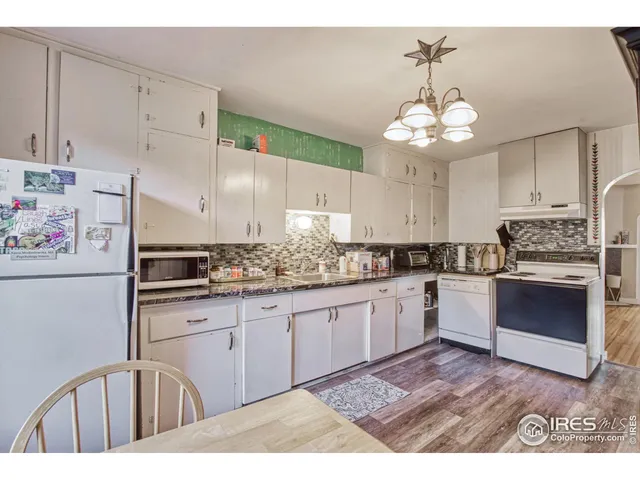 a kitchen with cabinets a center island and appliances