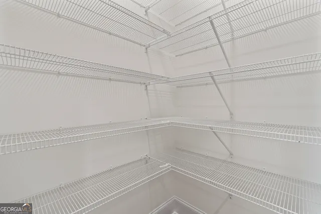 a view of an empty room with window and closet