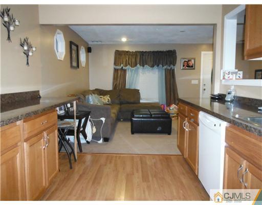 61 Glenville Road Edison, NJ 08817 - Photo 1 of 10 a kitchen with granite countertop a stove top oven a sink a dining table and chairs