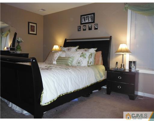 61 Glenville Road Edison, NJ 08817 - Photo 2 of 10 a bedroom with a bed and a night stand