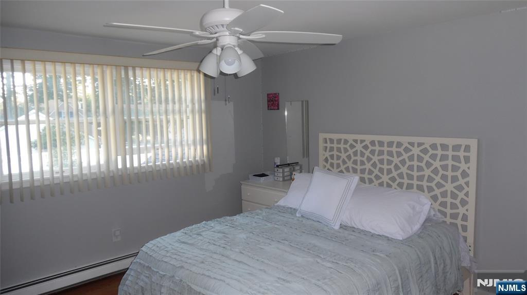 26 James Terrace Pompton Lakes, NJ 07442 - Photo 24 of 43 a bedroom with a large bed and a chandelier