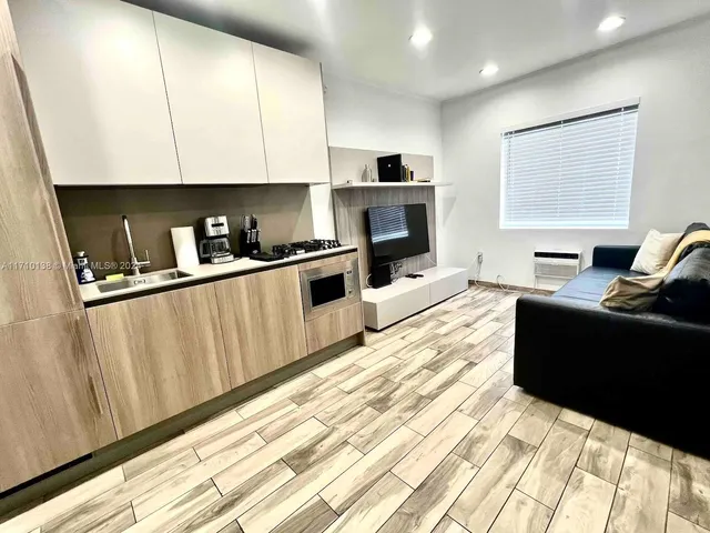 a kitchen with stainless steel appliances kitchen island granite countertop a refrigerator a stove top oven a sink and dishwasher