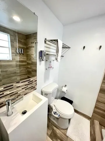 a bathroom with a sink a toilet and shower