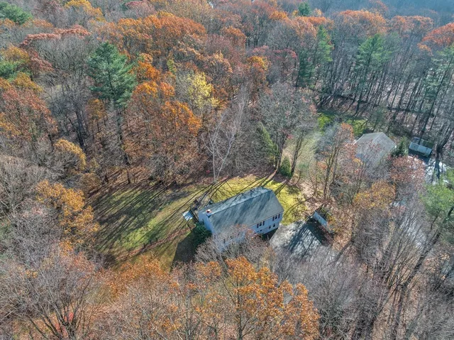 a backyard of a house with large trees and wooden fence