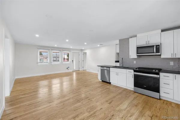 a large kitchen with stainless steel appliances granite countertop a stove a sink and a microwave