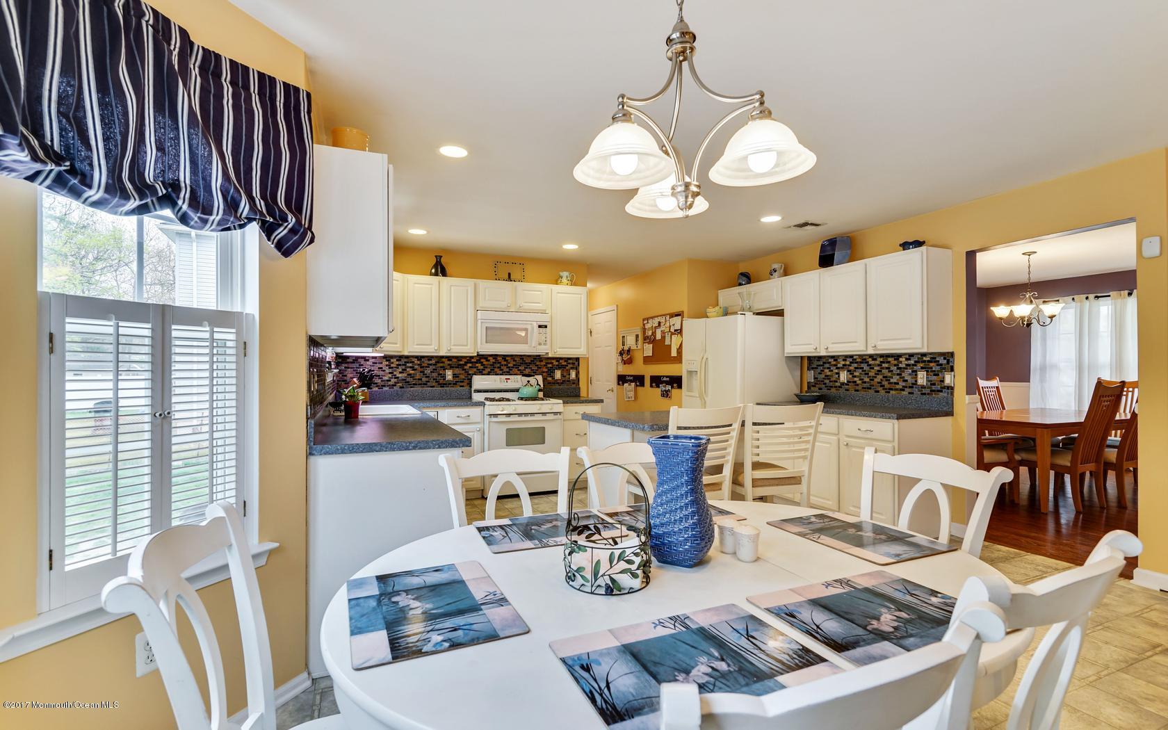 133 Bowsprit Road Manahawkin, NJ 08050 - Photo 13 of 32 a kitchen with stainless steel appliances kitchen island granite countertop a table and chairs in it
