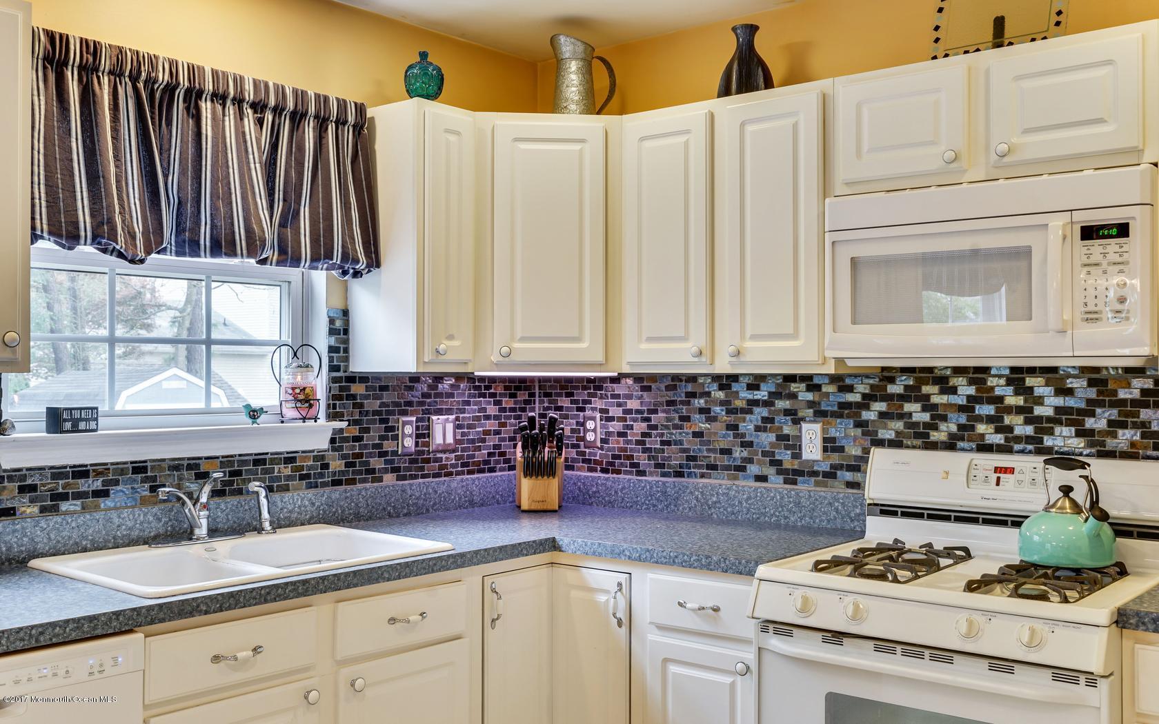 133 Bowsprit Road Manahawkin, NJ 08050 - Photo 31 of 32 a kitchen with granite countertop a sink a stove and cabinets