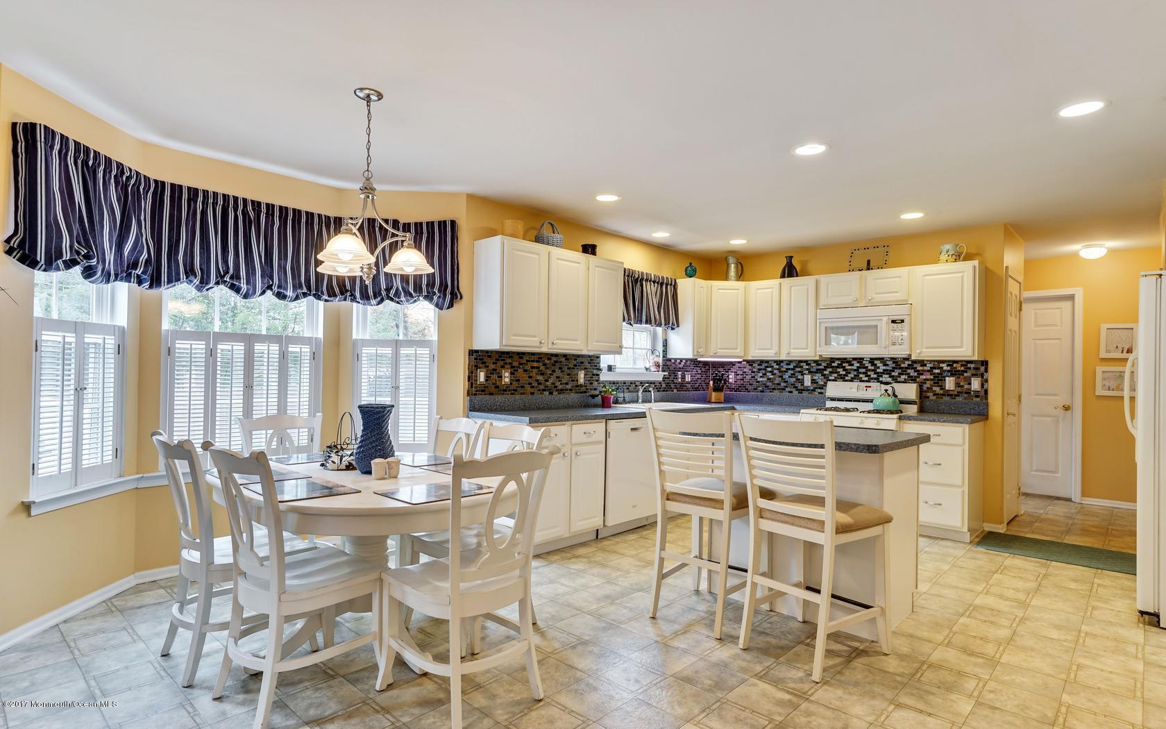 133 Bowsprit Road Manahawkin, NJ 08050 - Photo 10 of 32 a kitchen with stainless steel appliances kitchen island granite countertop a table and chairs