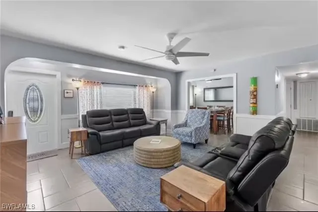 a living room with furniture a ceiling fan and a rug