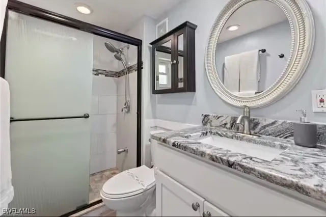 a bathroom with a granite countertop sink toilet and a mirror