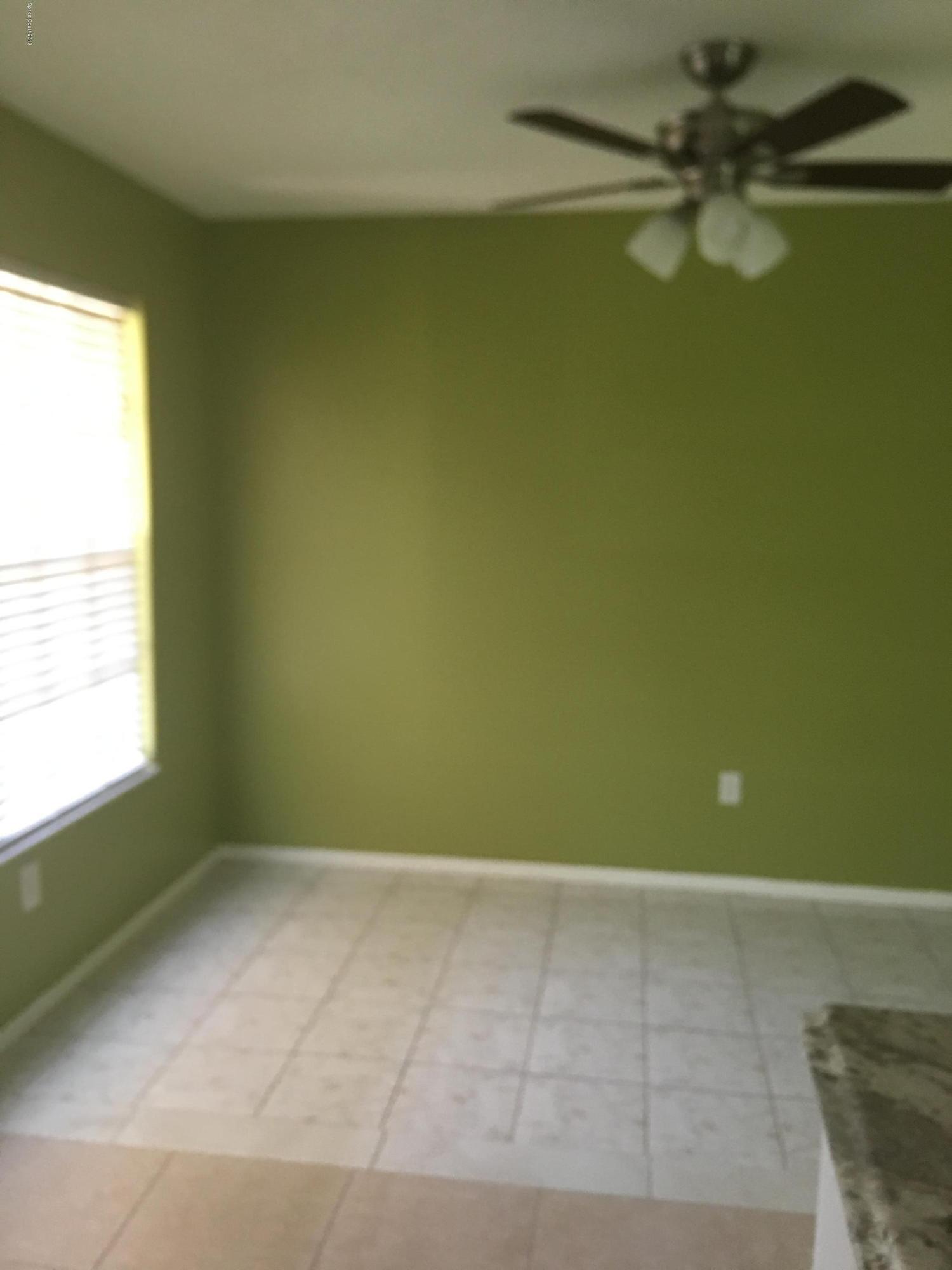 1272 Cromey Road Northeast Palm Bay, FL 32905 - Photo 50 of 53 an empty room with a window and a fan
