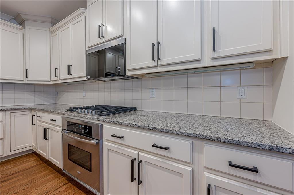 247 Fowler Street Woodstock, GA 30188 - Photo 17 of 72 a kitchen with granite countertop white cabinets and a stove