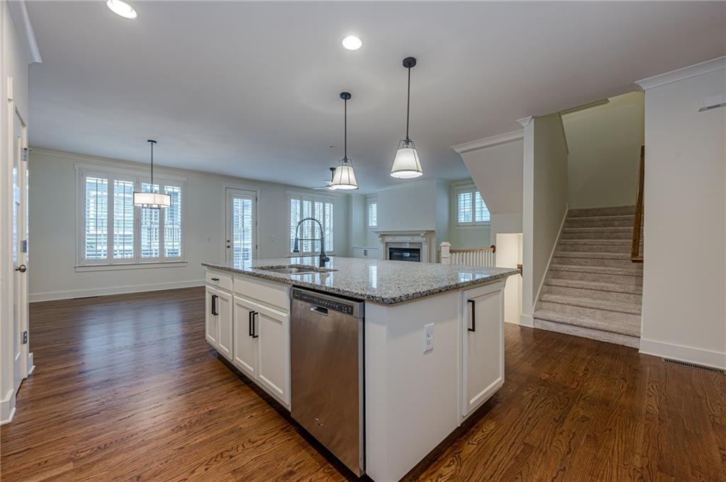 247 Fowler Street Woodstock, GA 30188 - Photo 18 of 72 a kitchen with stainless steel appliances granite countertop wooden floors and sink